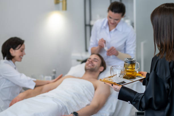 Beauty salon. Smiling young man enjoying skin procedures in the salon