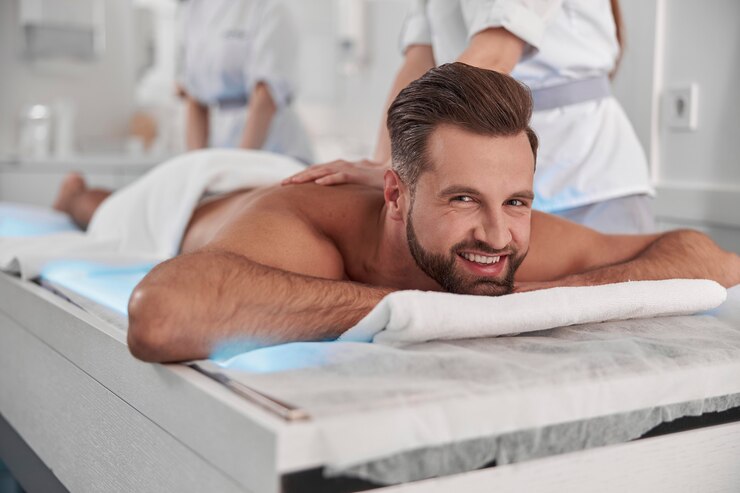 man-undergoes-relaxing-massage-procedure-with-professional-chiropractics-lying-glowing-couch_386167-5340